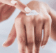 Woman applying dermal therapy hand balm