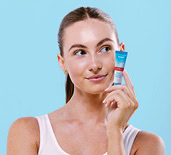 Alex Davidson holding a Dermal Therapy product as part of the It Works Campaign.