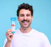 Matty J holding a Dermal Therapy Hand Balm Tube