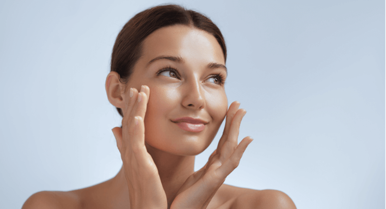 A woman with her hands on her face, applying face cream thinking about urea in moisturisers vs. other ingredients such as glycerin, hyaluronic acid, and oils