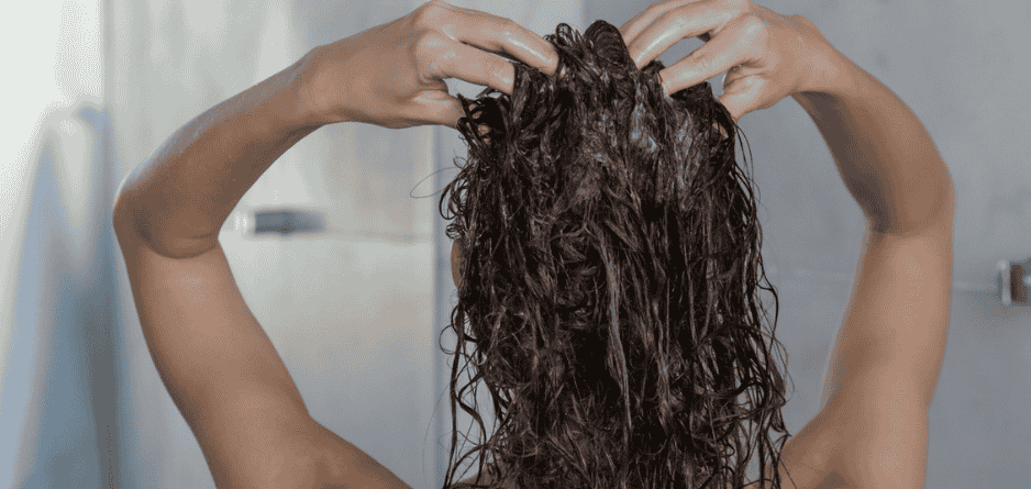 A woman in the shower washing her hair and addressing Flakiness with Scalp Relief Shampoo: What Works Best?