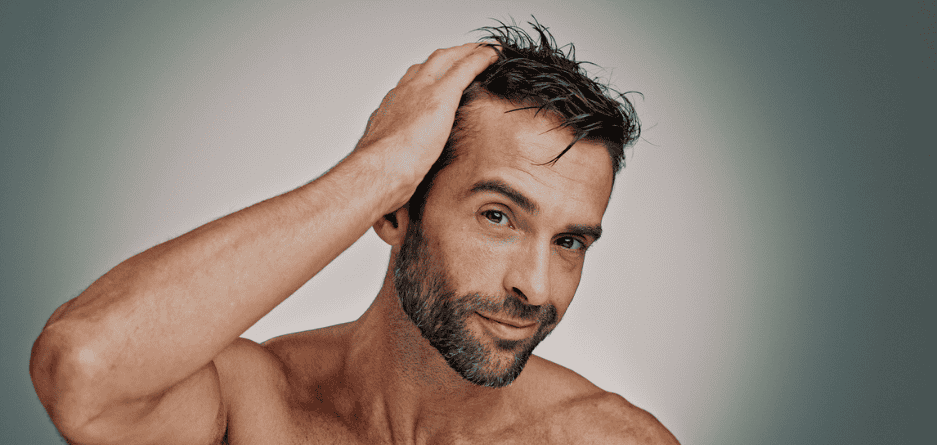 A man with a beard running his hand through his hair thinking about how to get a health head.