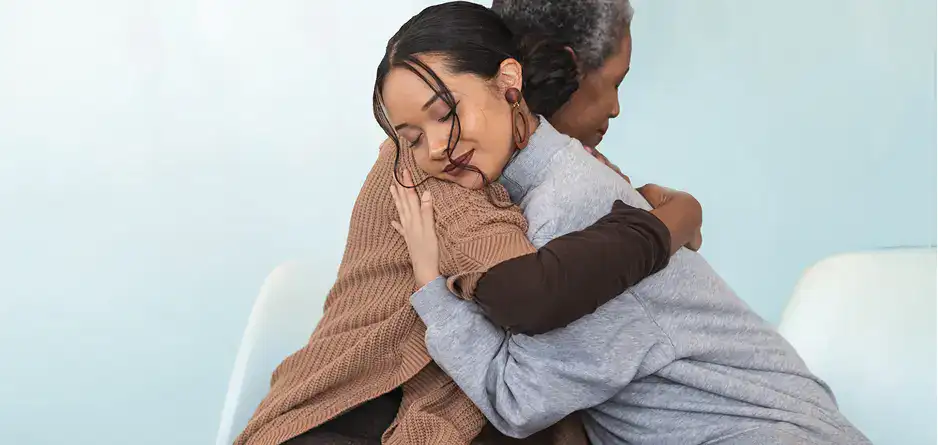 Two people having a hug thinking about the impact that eczema has on mental health