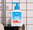 Dermal Therapy Very Dry Face Cleanser pump bottle placed in a shower caddy against white tiled walls