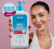 Dermal Therapy Very Dry Skin Wash pump bottle held in front of a person against a pink background