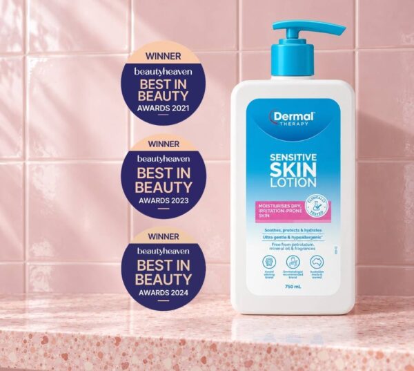 Bottle of Dermal Therapy Sensitive Skin Lotion displayed on a pink tiled surface beside three award badges.